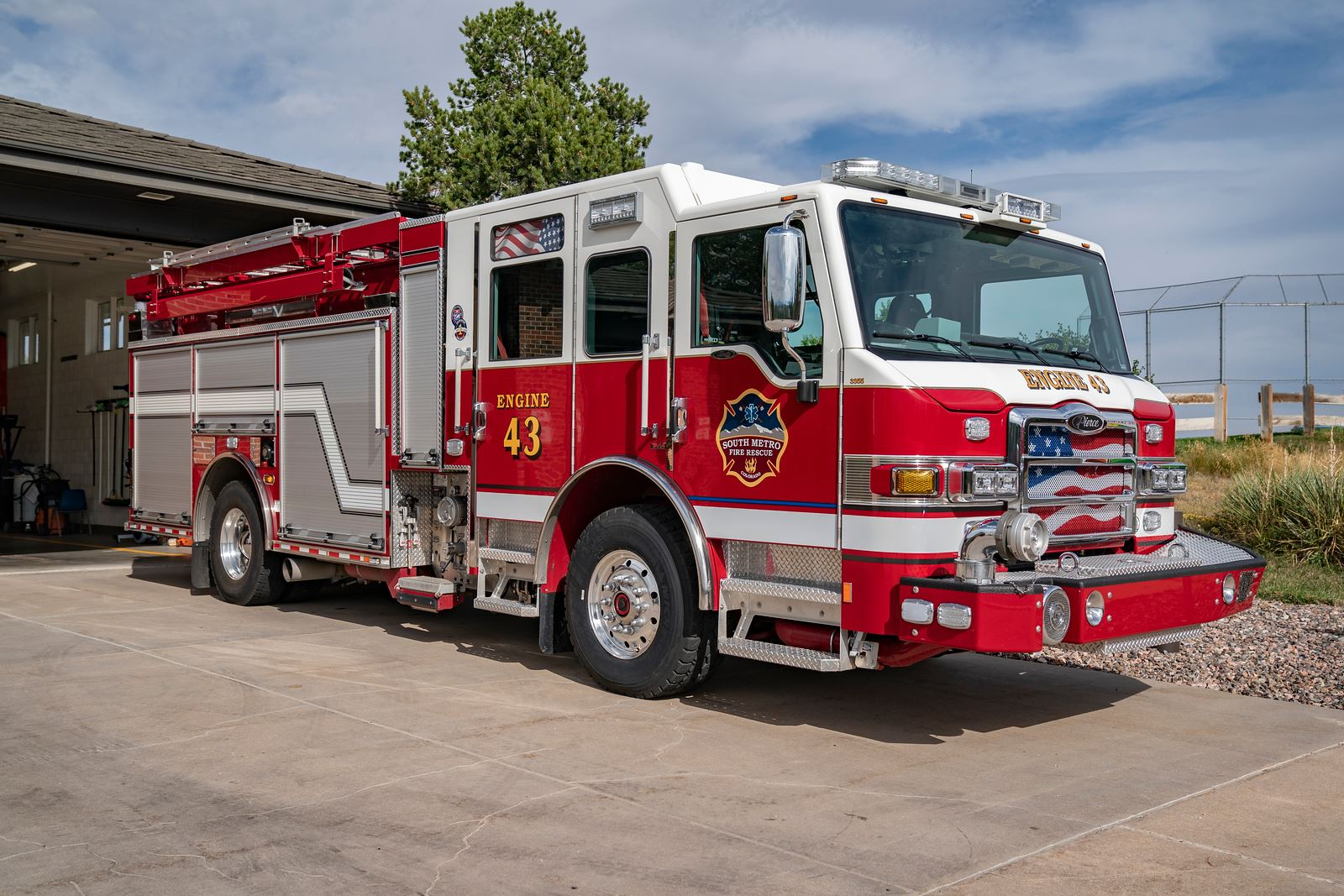 A red fire truck (Engine 43) parked outside a fire station.