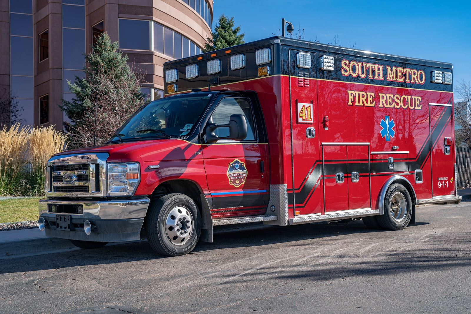 A red South Metro Fire Rescue ambulance parked on a street.