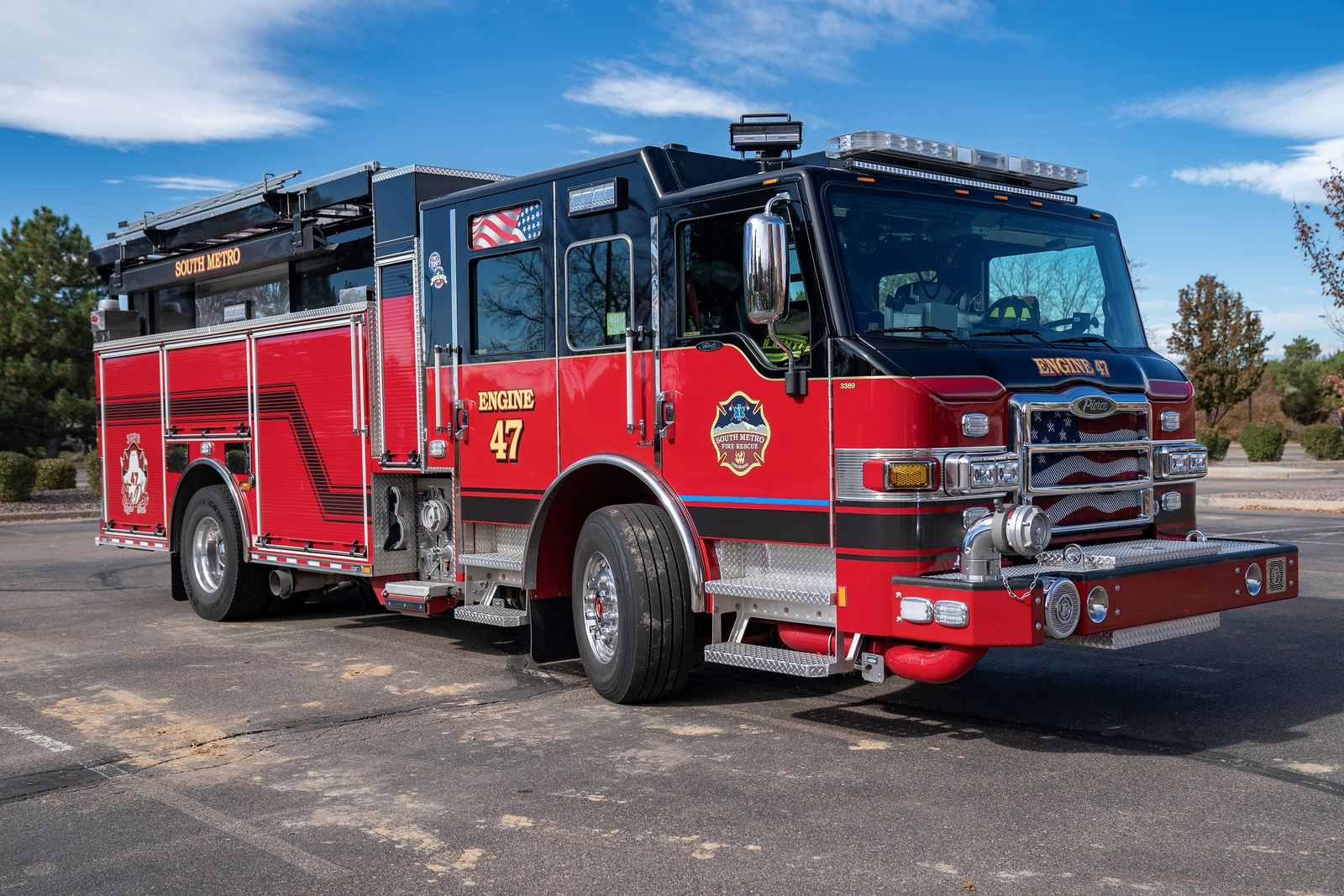 A red fire truck labeled "Engine 47" parked outdoors on a clear day.