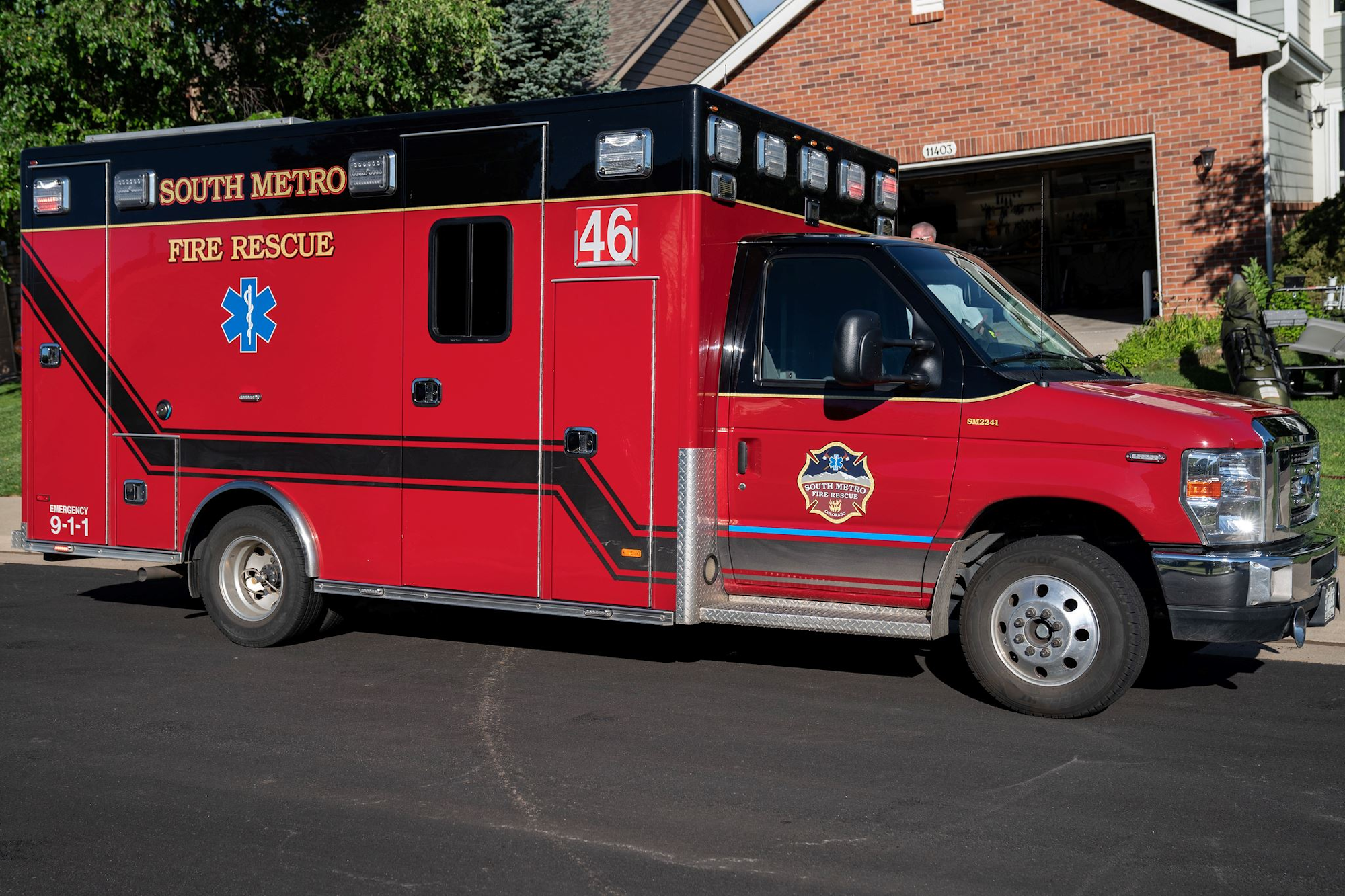 Red fire rescue ambulance with "South Metro" markings parked in a residential area.