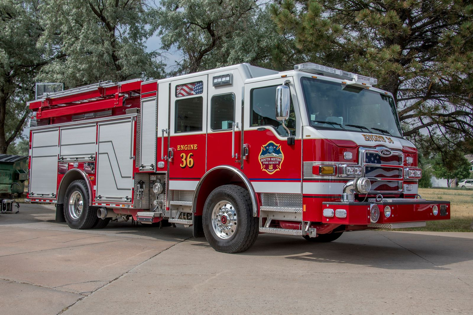 Red fire truck labeled "Engine 36" with trees in the background.