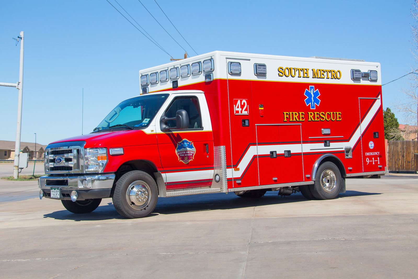 A red fire rescue ambulance labeled "South Metro" parked on a sunny street.