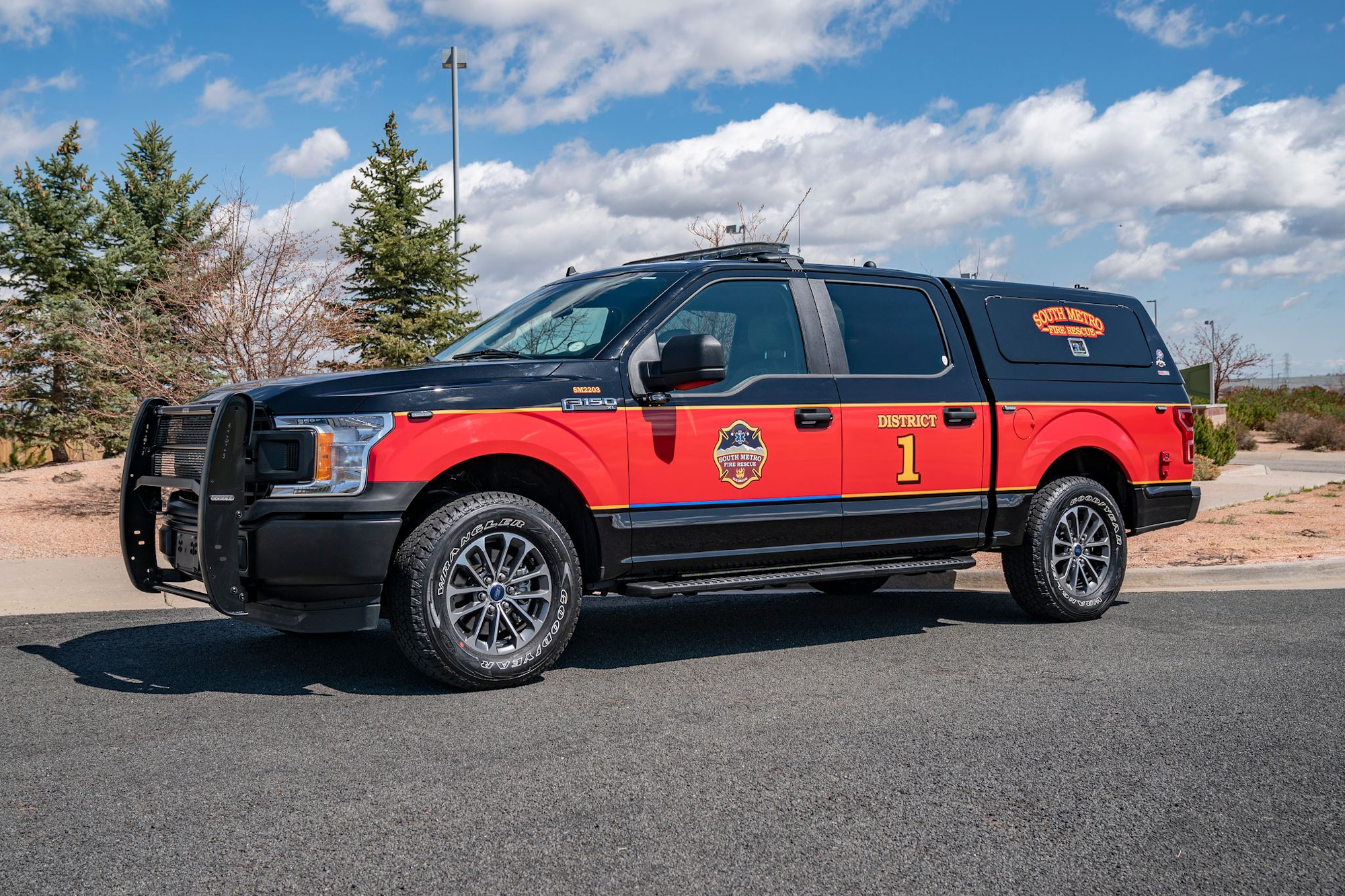Fire department vehicle marked "District 1" with "South Metro Fire Rescue" logo, parked outdoors under a clear sky.