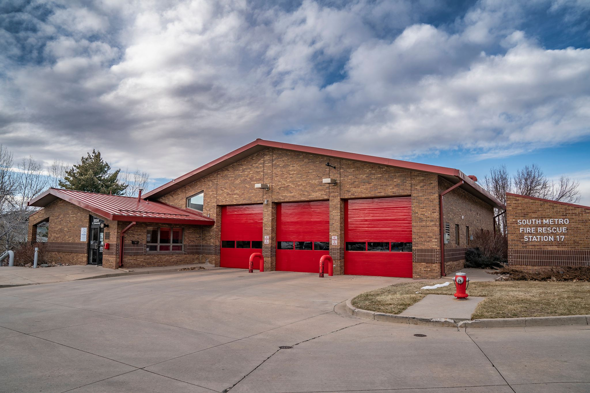 Fire station with red garage doors and a fire hydrant outside. Sign reads "South Metro Fire Rescue Station 17."