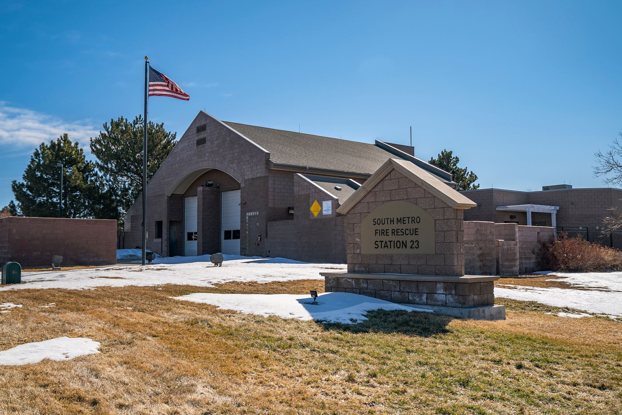 A fire station building with an American flag and a sign reading "South Metro Fire Rescue Station 23."