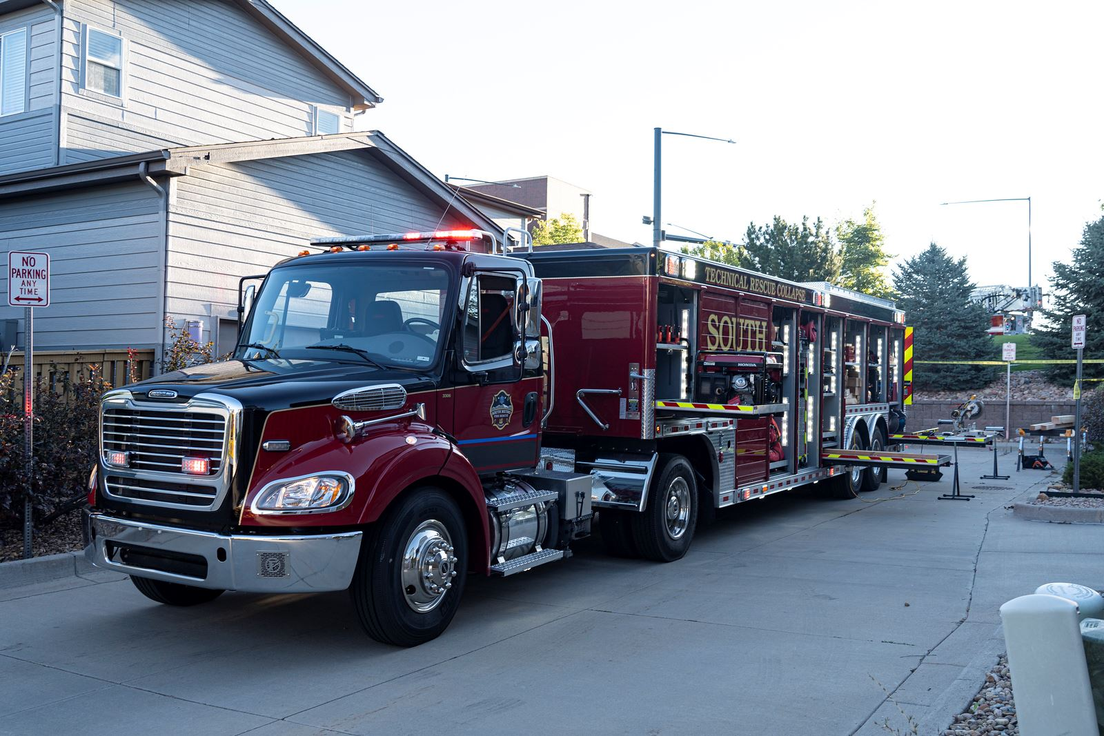 A red technical rescue truck parked on a residential street.