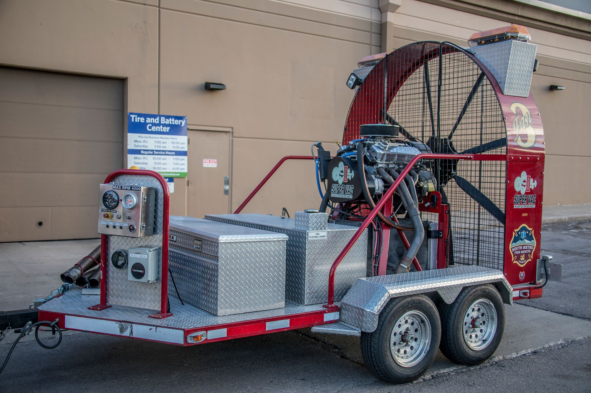 A large industrial fan mounted on a trailer, labeled "Super Vac," parked outside a building.