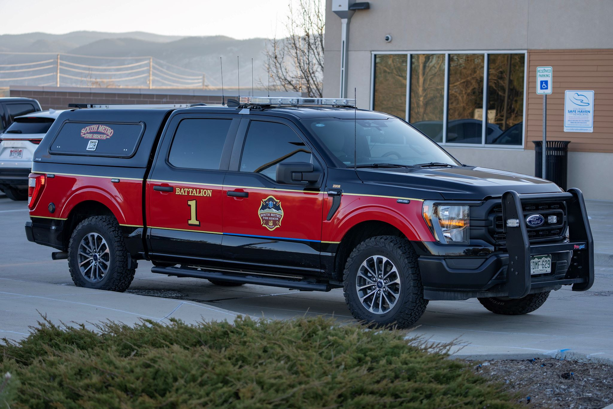 A red and black fire rescue truck labeled "Battalion 1" parked outside a building with "South Metro Fire Rescue" insignia.