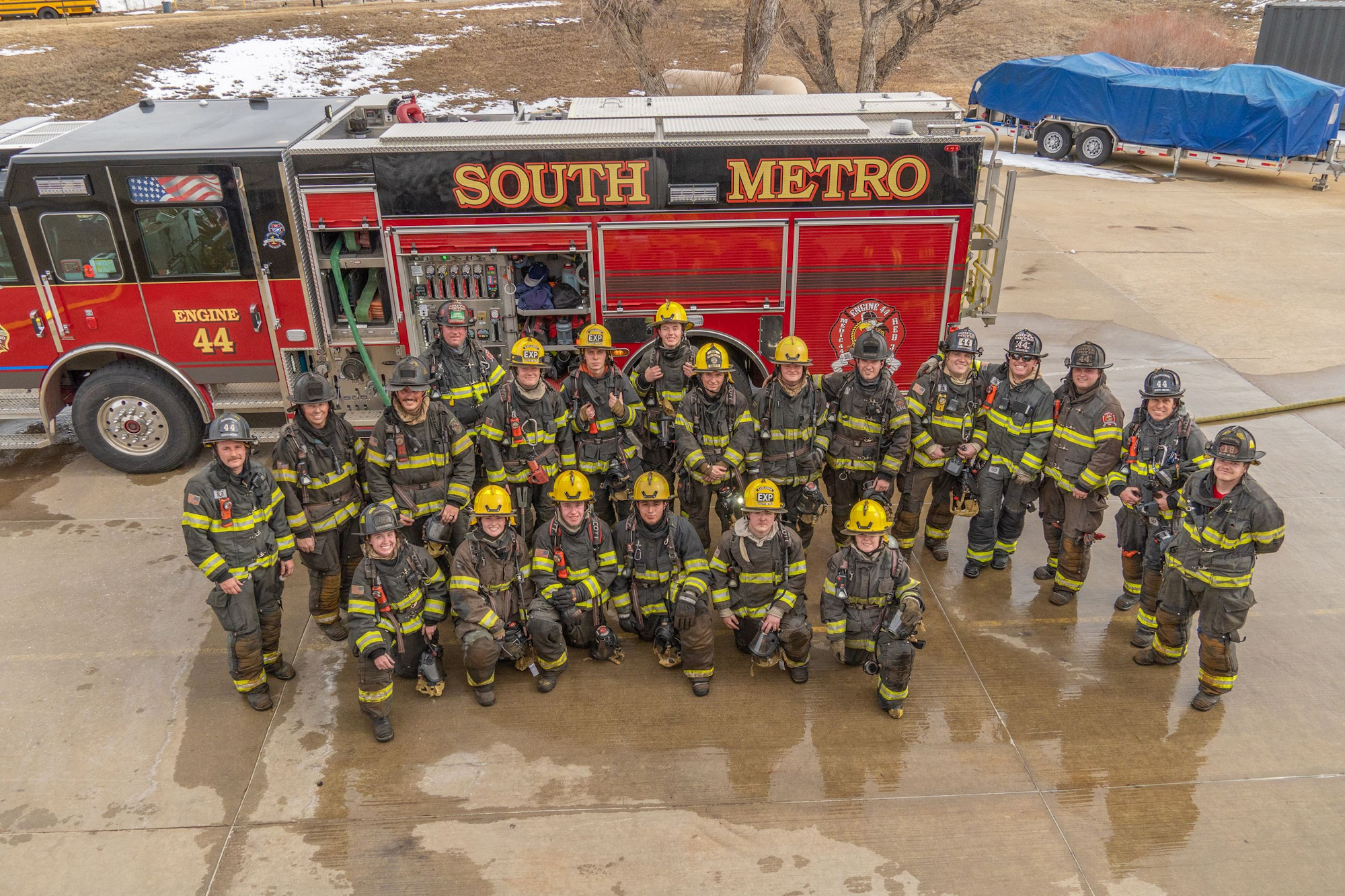 A group of firefighters poses in front of a red fire truck labeled "SOUTH METRO," ready for action.