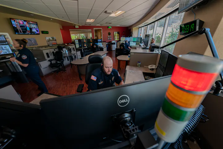 An emergency operations center with staff monitoring screens and a communication system, focused on real-time responses.