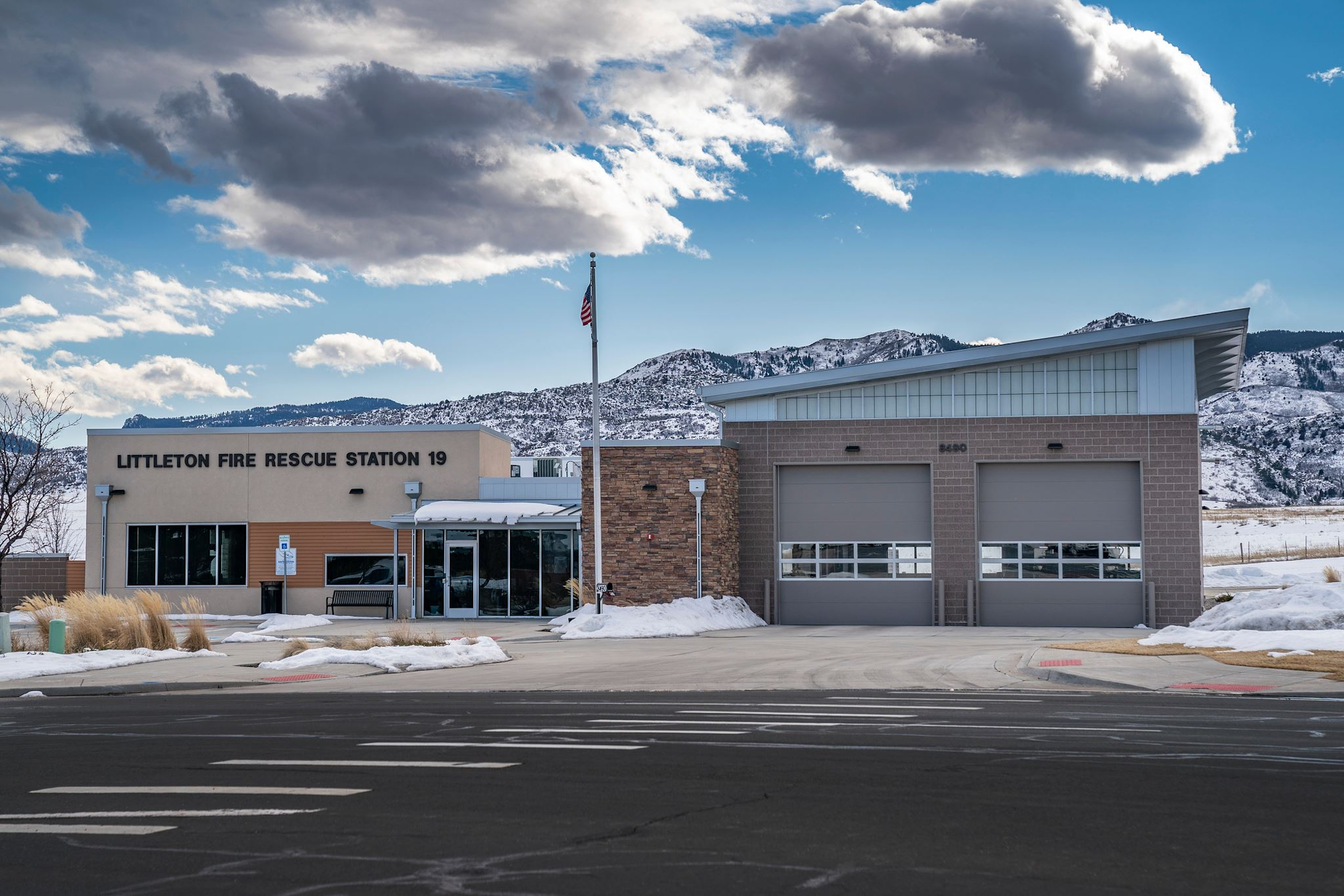 Littleton Fire Rescue Station 19 with mountains, snow, and an American flag in the background.