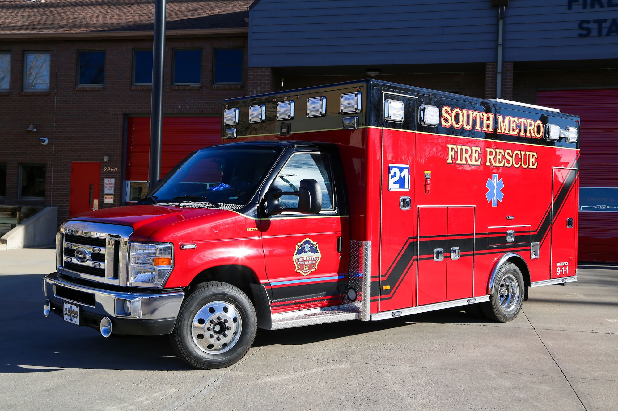 A red South Metro Fire Rescue ambulance parked outside a fire station.
