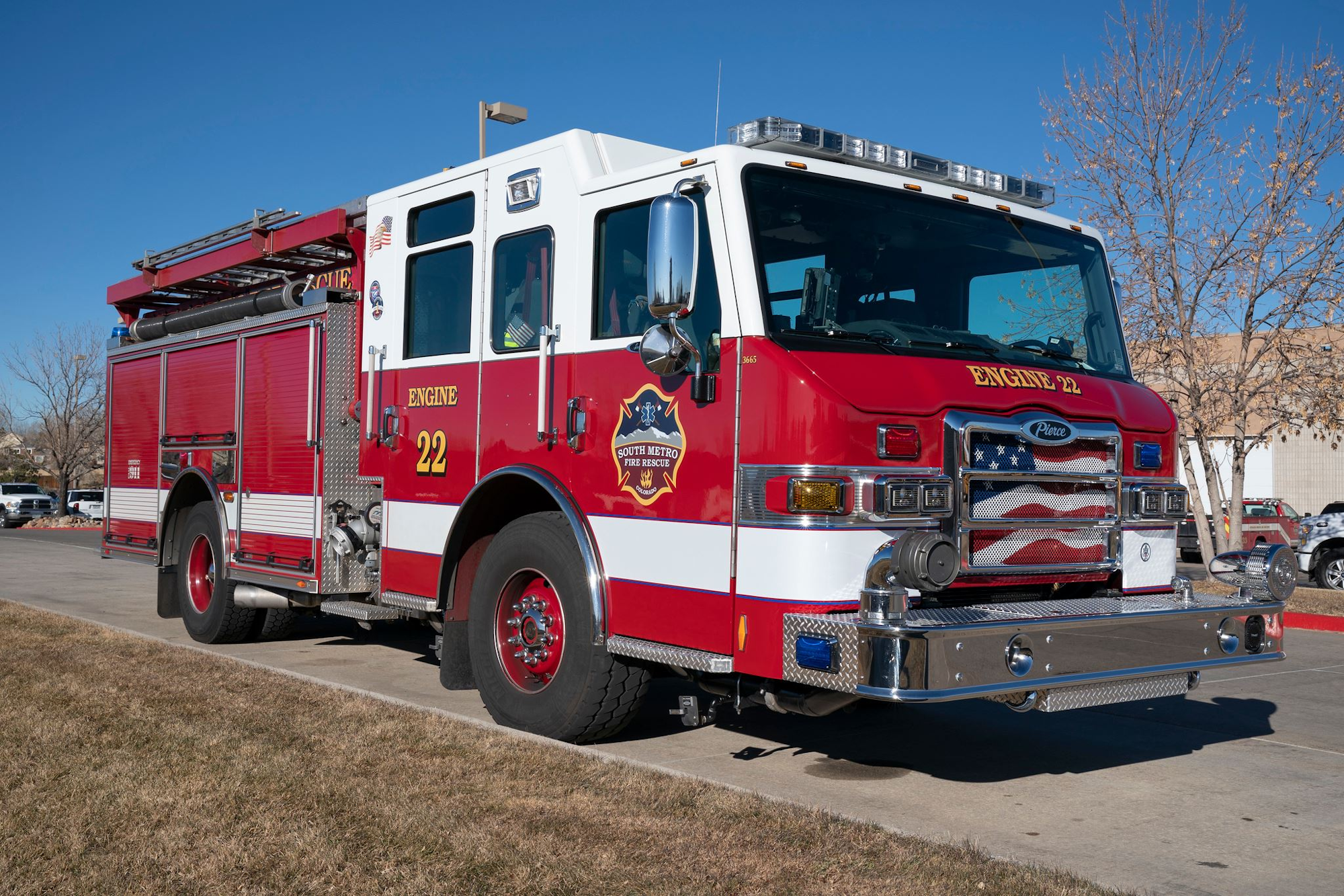 A red fire truck with "Engine 22" inscribed, parked outdoors on a clear day.