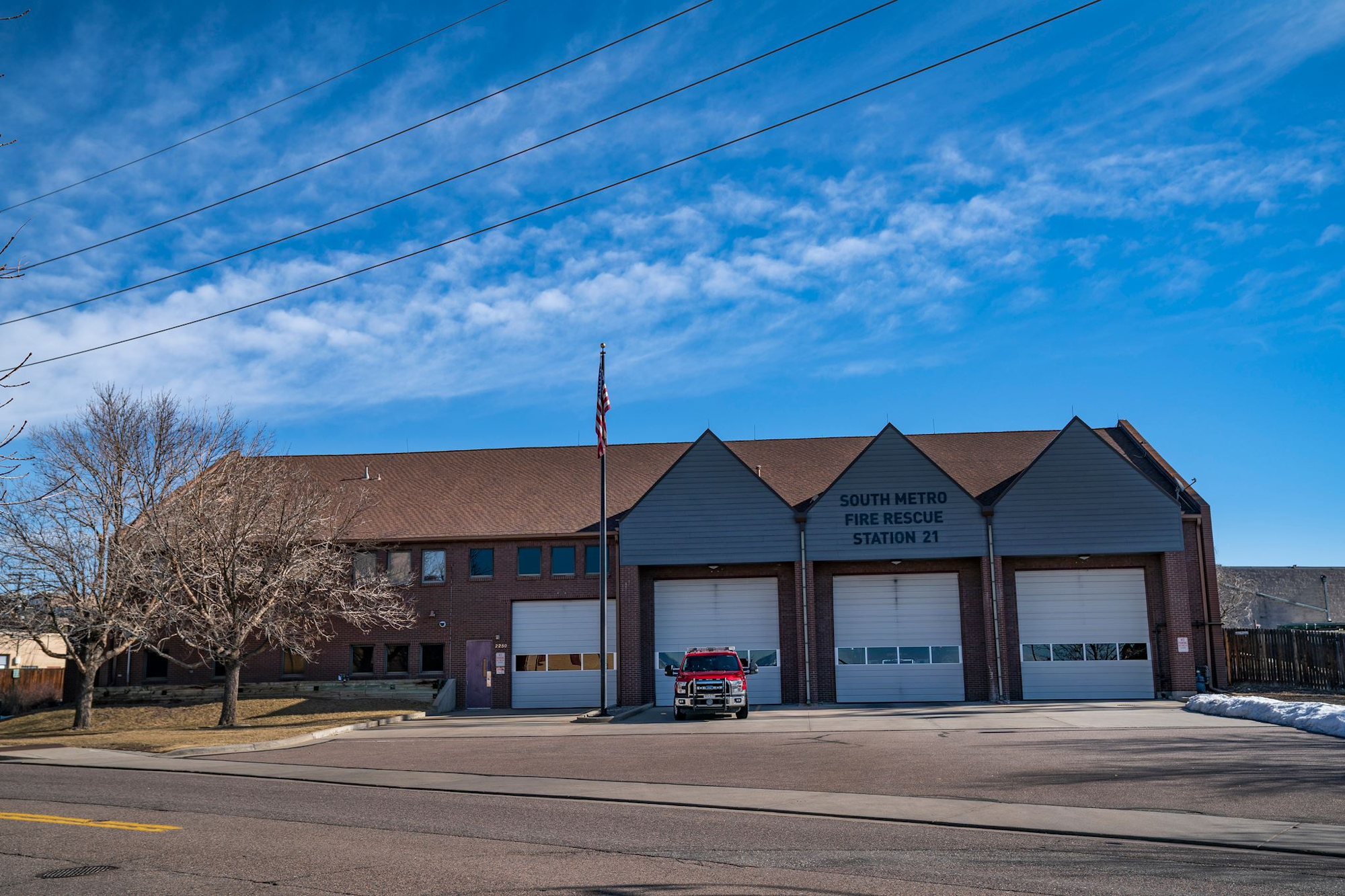 A fire station with "South Metro Fire Rescue Station 21" and a red fire truck parked in front.