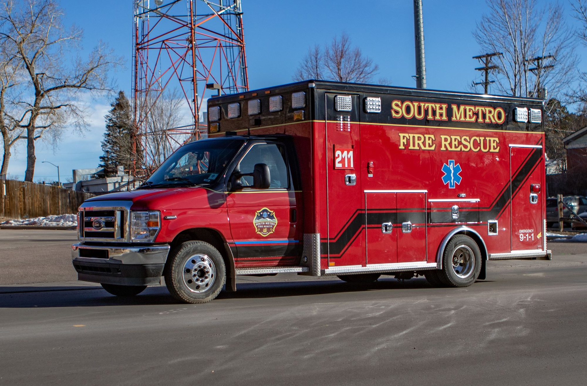 A red "South Metro Fire Rescue" ambulance parked on a street.