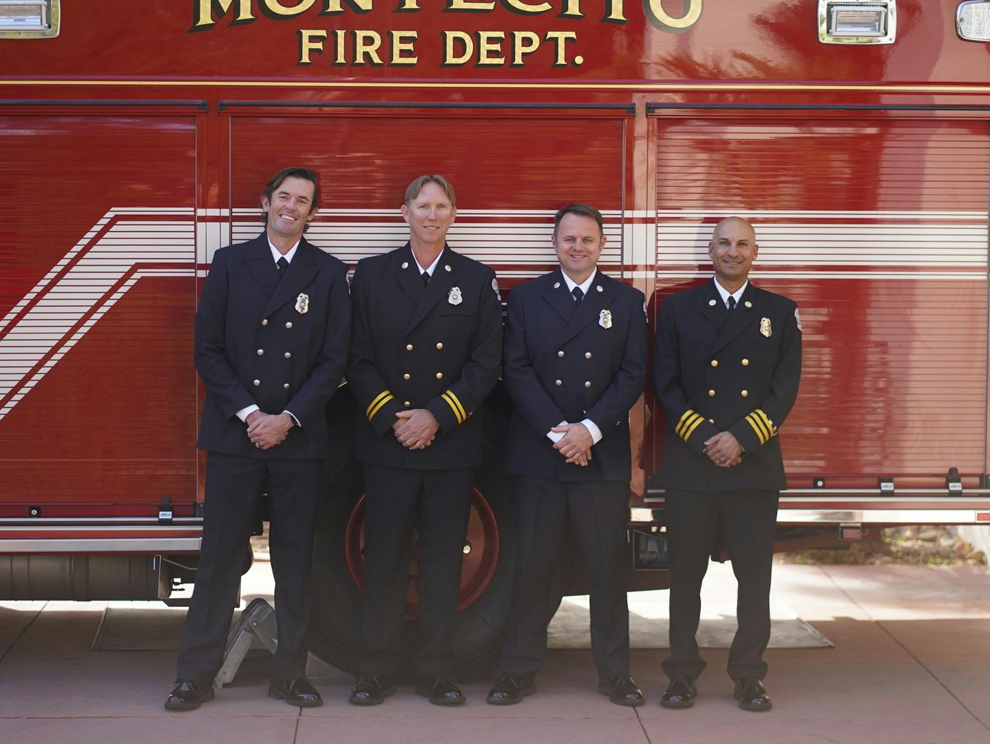 Four firefighters in uniform standing in front of a Montecito Fire Department truck.