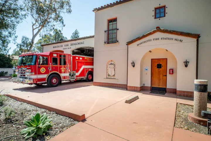 Image of Montecito Fire Station No. 92, featuring a red fire truck partially in the bay and the building's entrance.