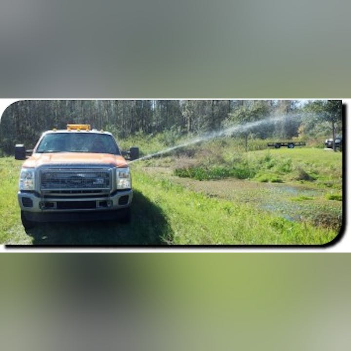 Larvicide truck spraying a ditch showing in-house design modification