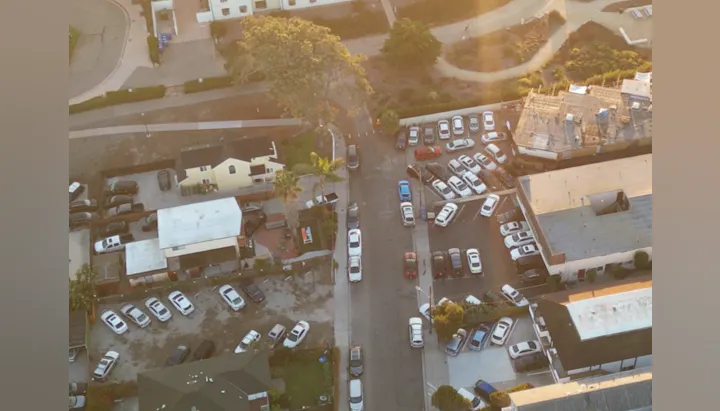 Aerial view of parked cars and buildings during sunset.