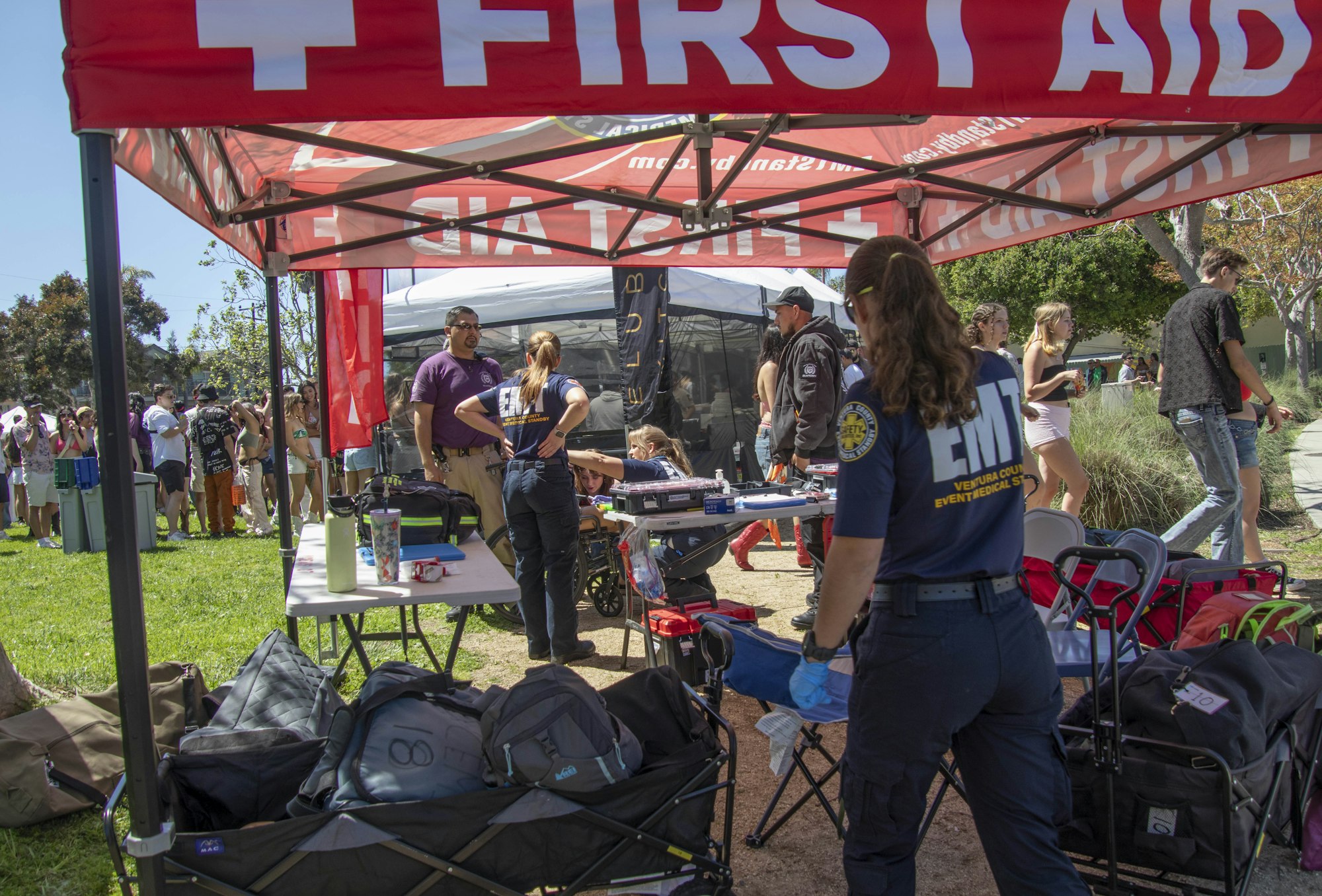 A first aid station with medical personnel and equipment at an outdoor event.