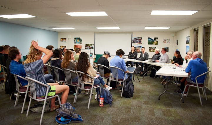 May contain: cafeteria, indoors, restaurant, people, person, adult, female, woman, chair, furniture, male, man, architecture, building, school, classroom, room, and crowd