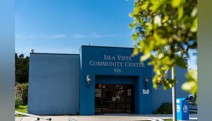 A photo showing the blue facade of the Isla Vista Community Center with clear skies in the background.