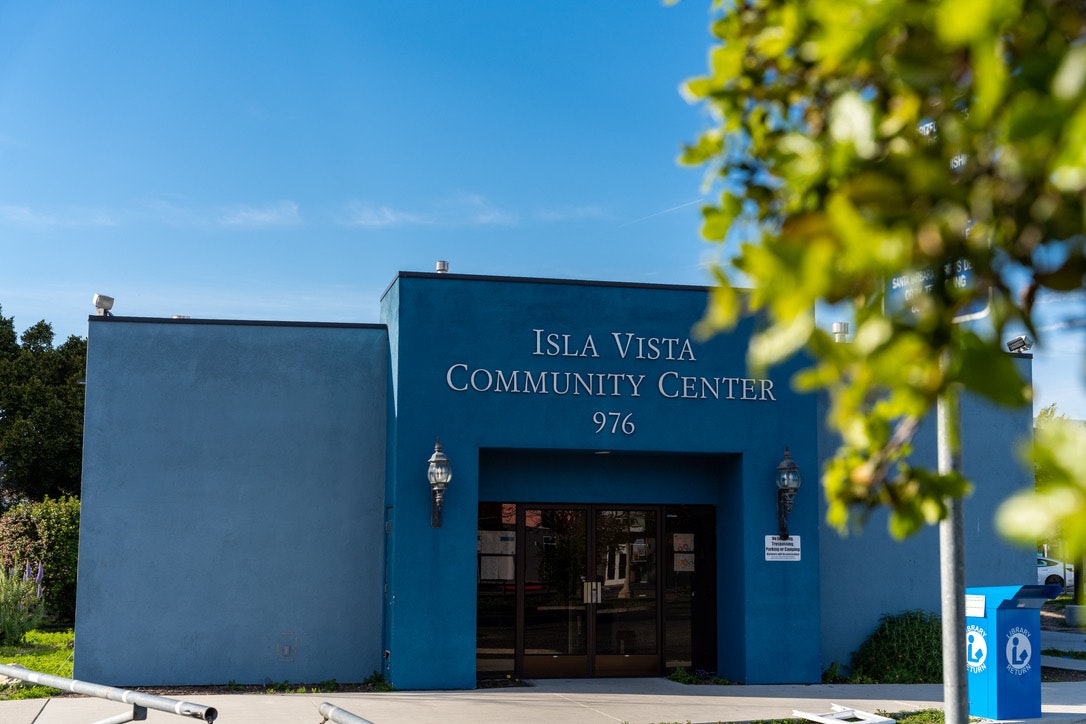A photo showing the blue facade of the Isla Vista Community Center with clear skies in the background.