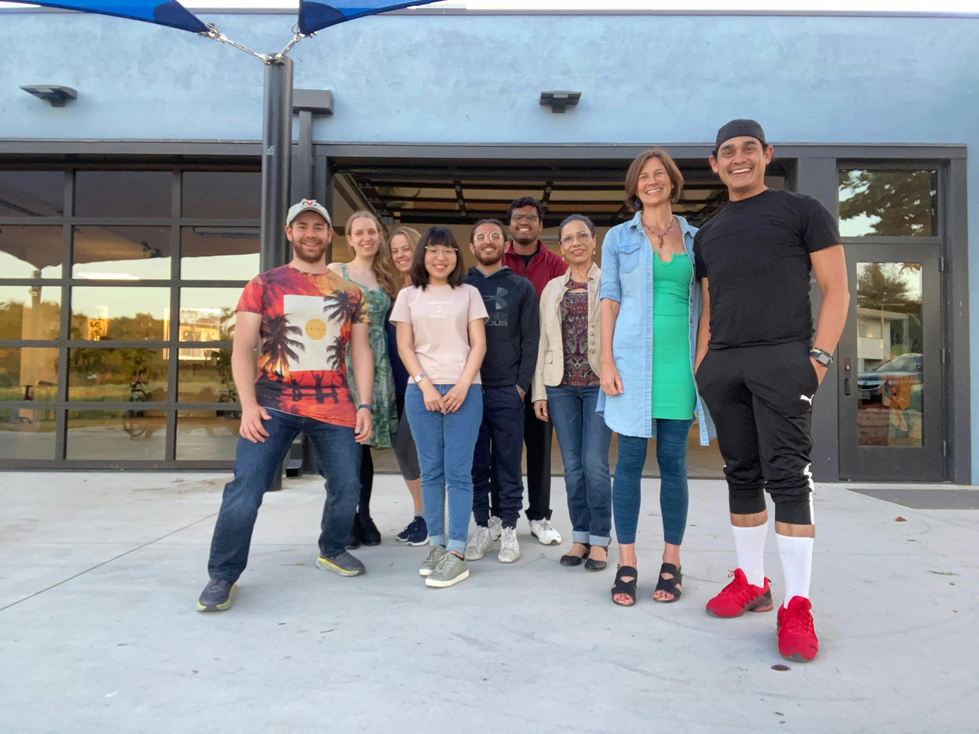May contain: clothing, pants, t-shirt, jeans, people, person, footwear, shoe, sandal, wristwatch, hat, groupshot, accessories, jewelry, necklace, car, transportation, vehicle, face, head, photography, and portrait