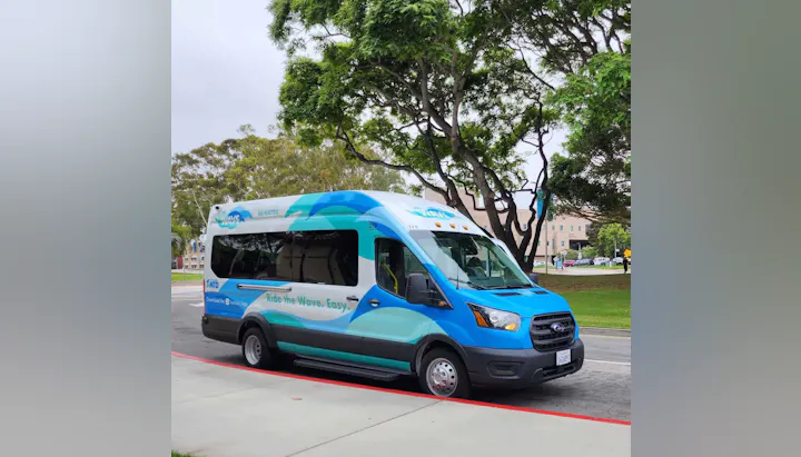 An all-electric transit vehicle with a blue and white design, promoting easy transportation with the slogan "Ride the Wave. Easy."