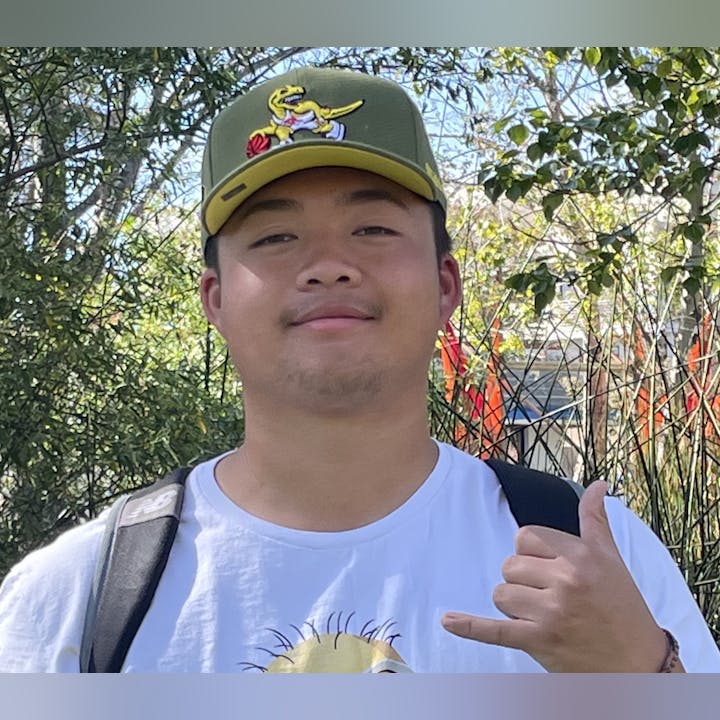 May contain: baseball cap, cap, clothing, hat, body part, finger, hand, person, face, head, photography, portrait, t-shirt, adult, male, man, plant, and vegetation