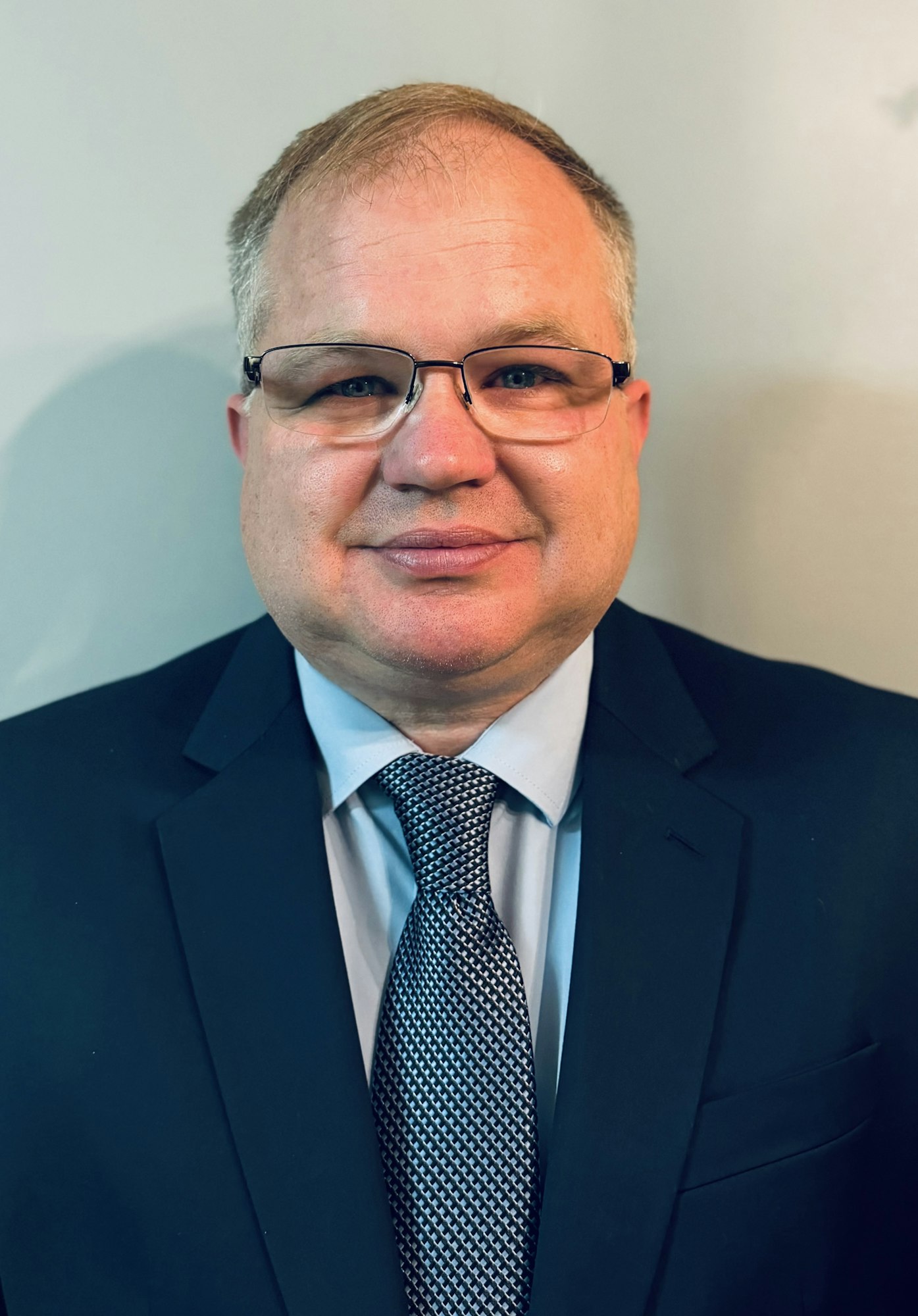A man in a suit and tie wearing glasses.