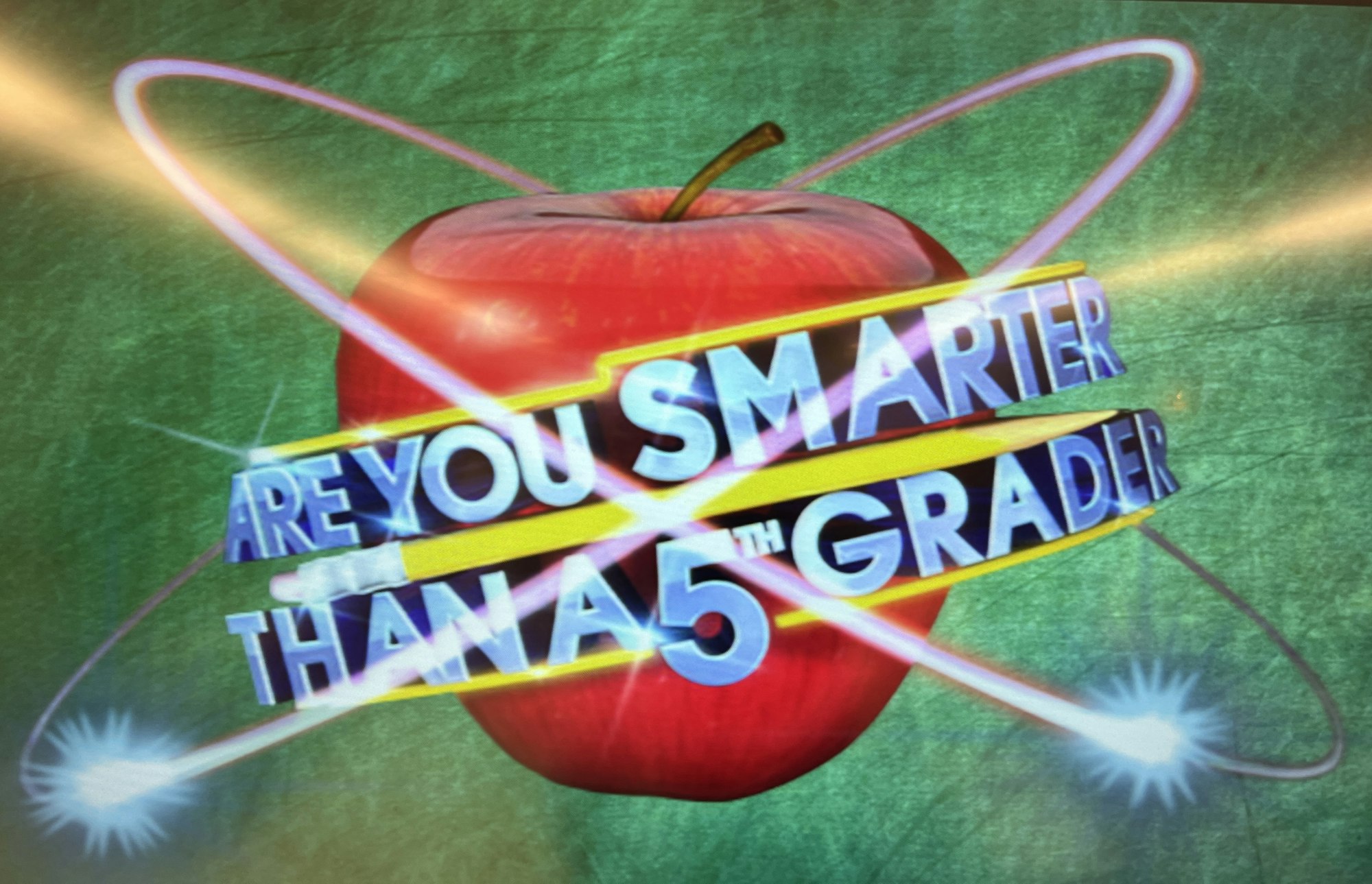 An image featuring a red apple and text asking, "Are You Smarter Than a 5th Grader?" against a green background.
