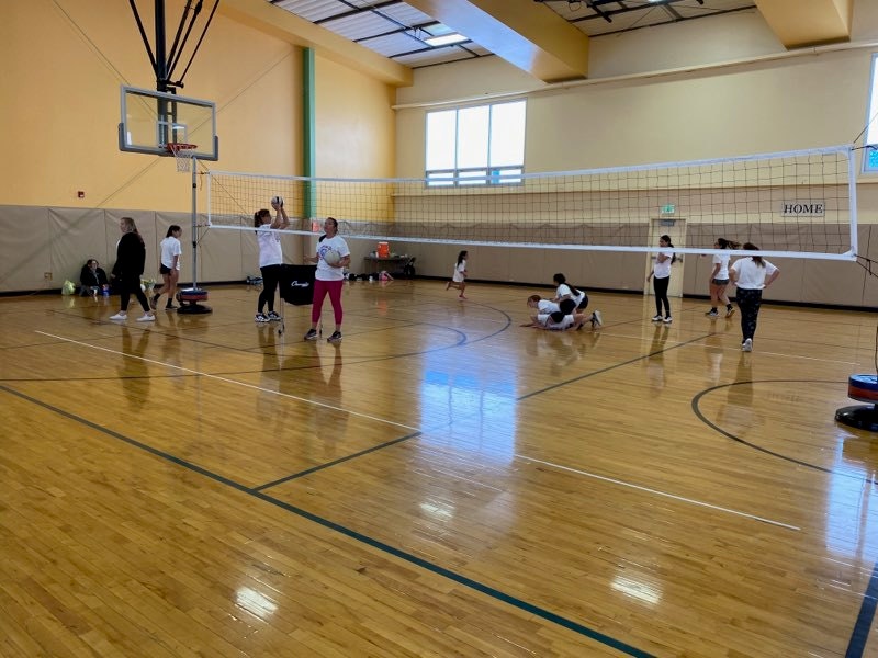 People playing volleyball indoors.