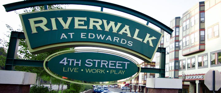Sign reading "RIVERWALK at EDWARDS" above "4TH STREET LIVE • WORK • PLAY", buildings in the background.