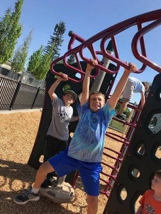 Children playing on monkey bars at a playground.