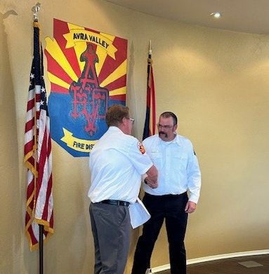 Chief Delfs congratulates Battalion Chief Bowden 2-26-26