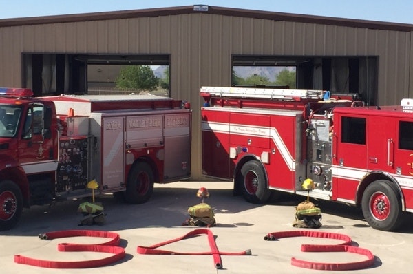 9-11 Memorial at ST 194 showing two fire engines gear and hoses on the ground.