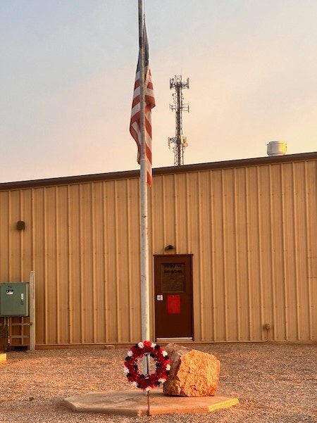 9-11 memorial showing Flag at half-mast and wreath at twilight iat ST 191 - Sept 2024.