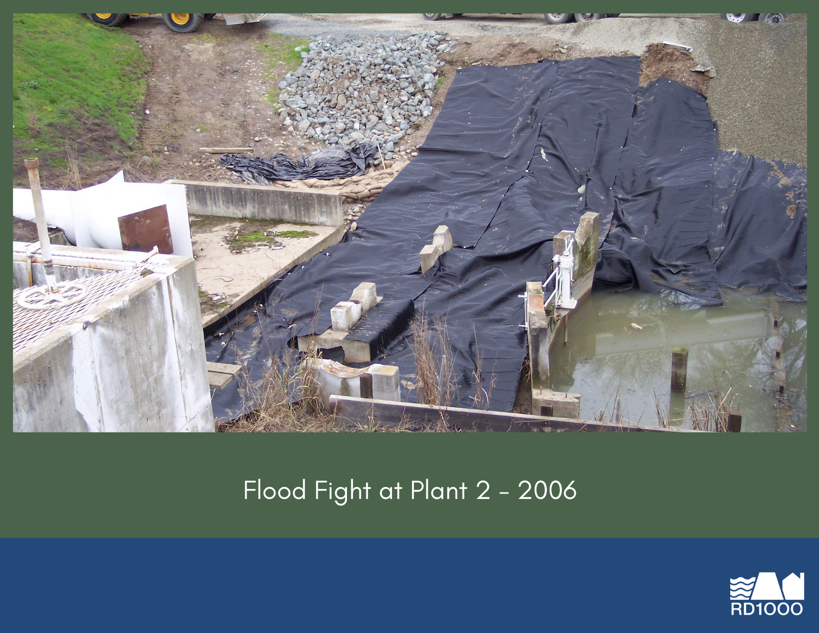 The image shows a flood fight at Plant 2 in 2006, featuring a protective barrier and surrounding landscape.