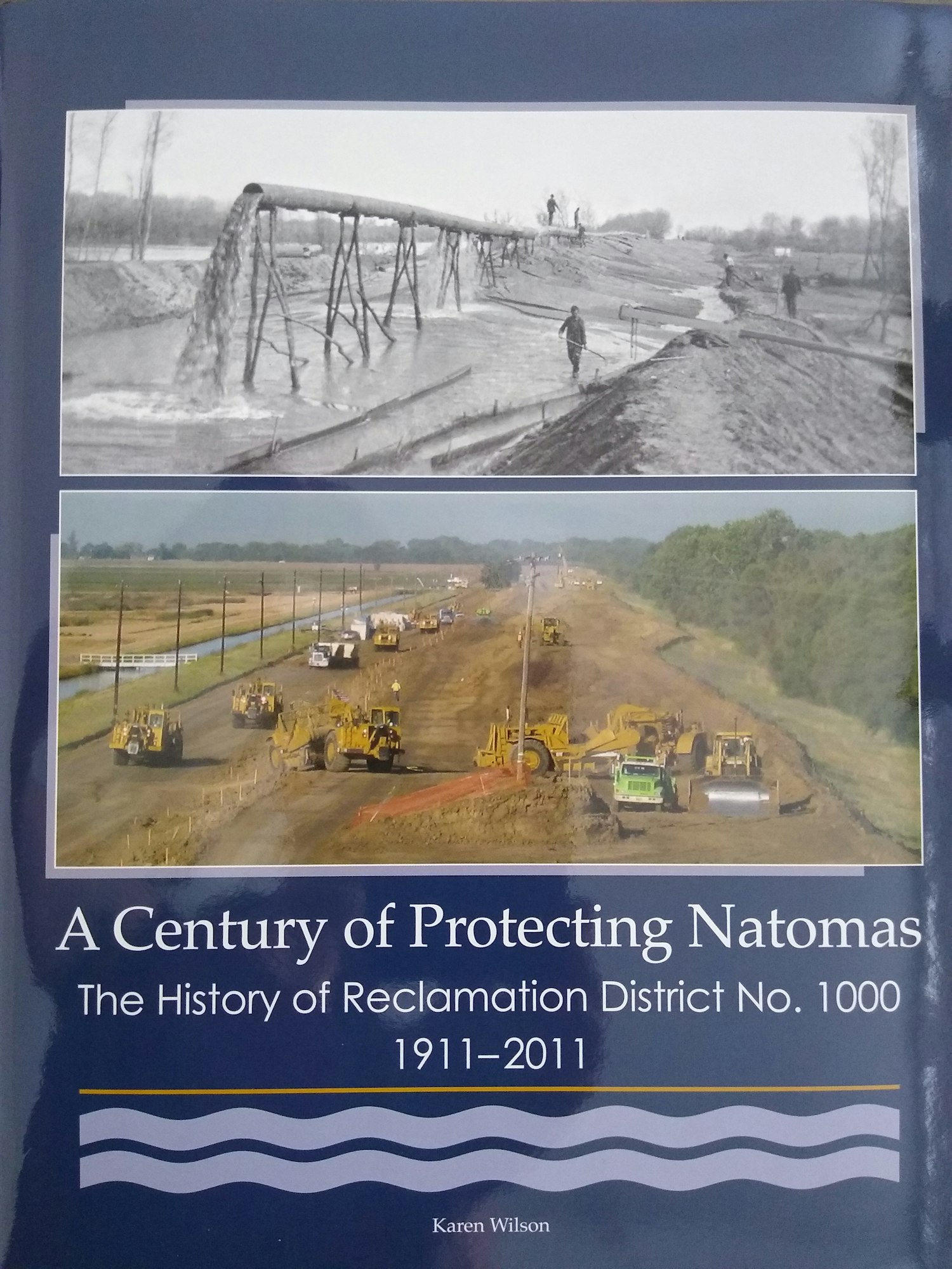 picture of RD1000 Centennial Book cover. Navy blue cover with historical and modern day photo titled "A Century of Protecting Natomas"