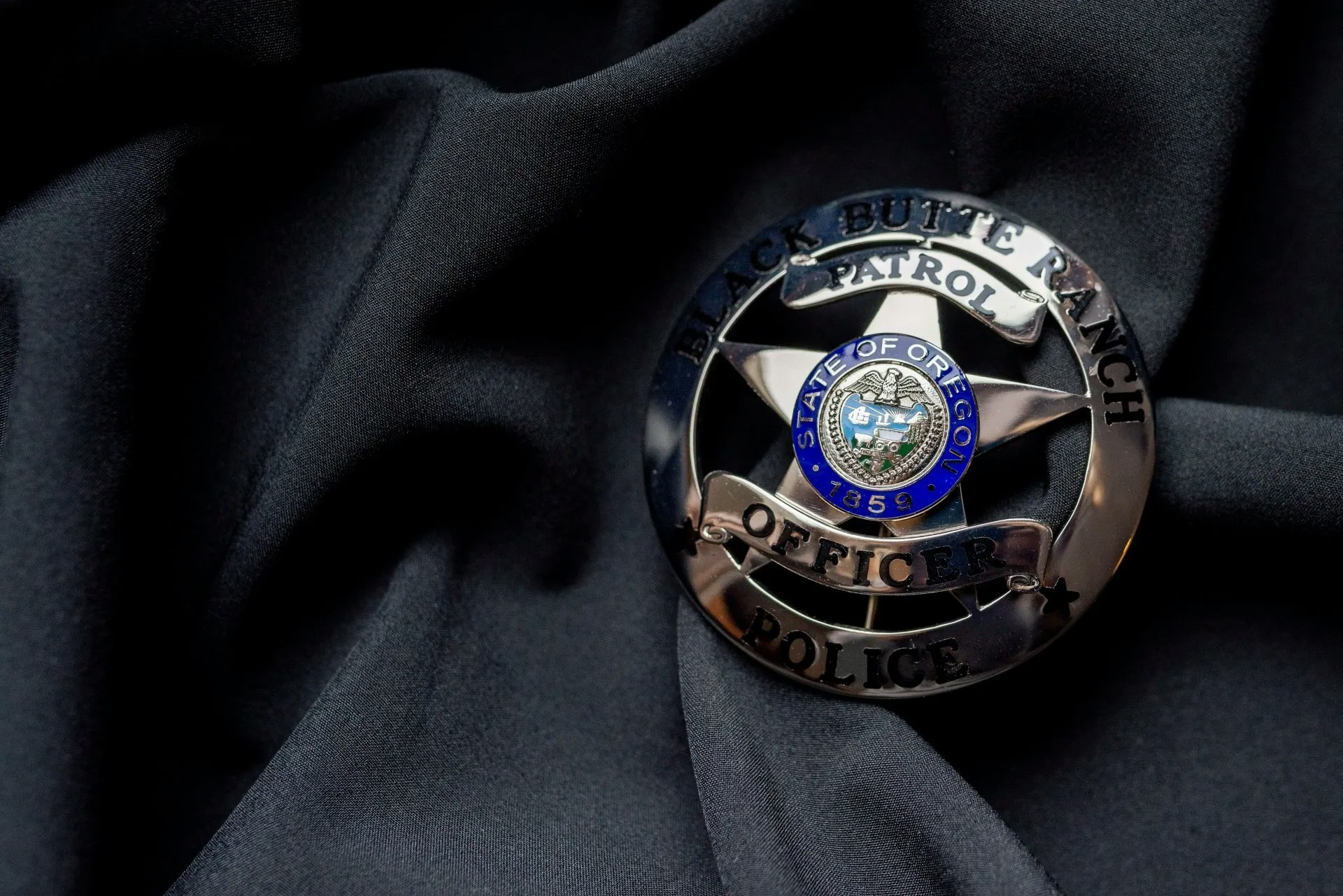 Police badge for Black Butte Ranch Patrol, Oregon, on a black fabric.