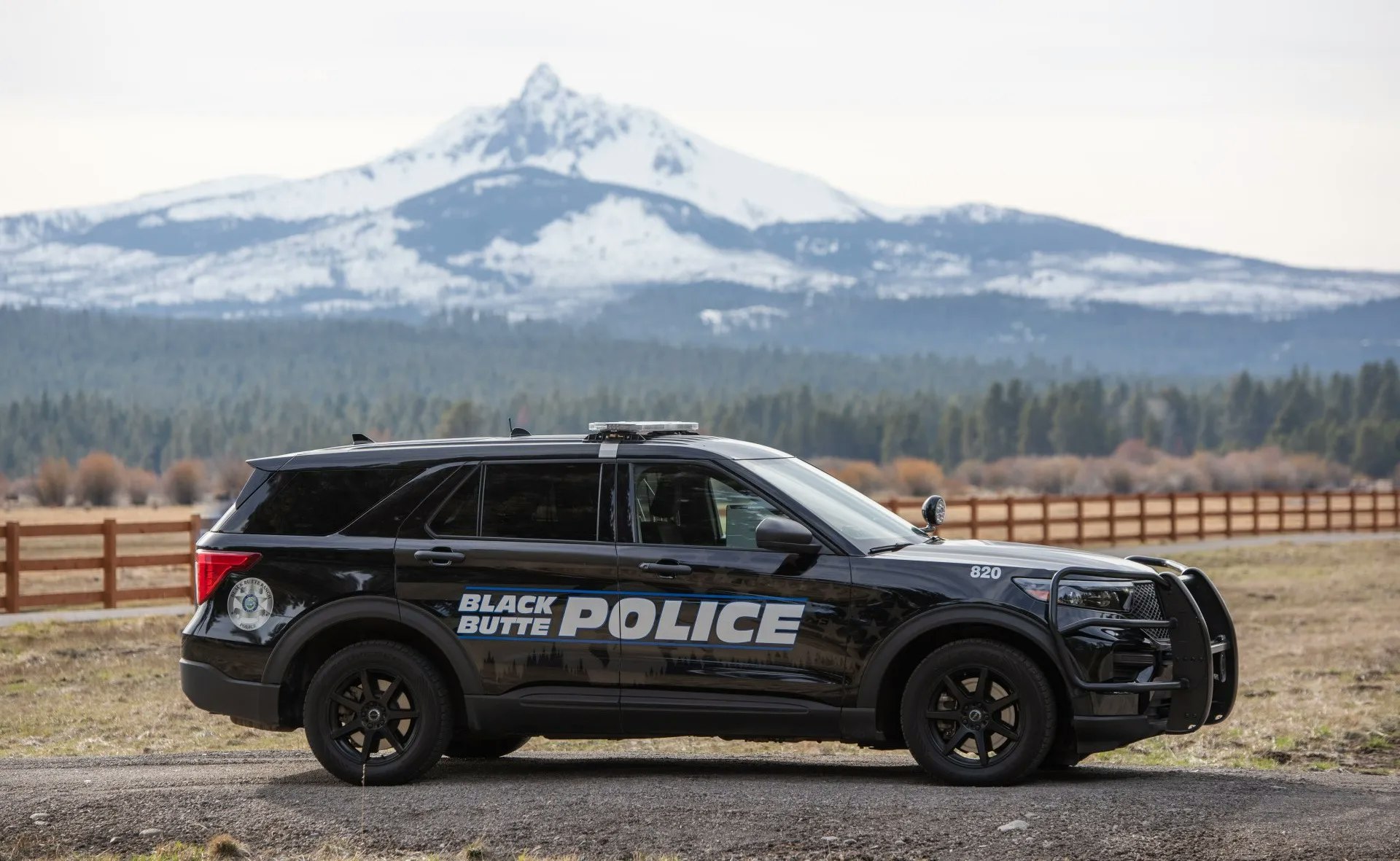 Black police SUV labeled "Black Butte Police" with mountains in the background.