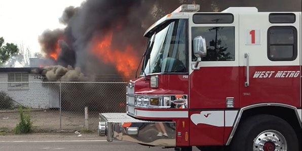 West Metro Engine 1 in foreground, with structure fire showing smoke and flames in the background