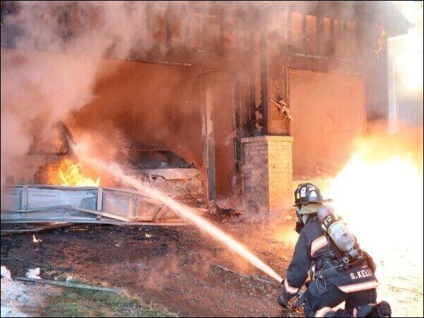 Firefighting using hose to extinguish flames during a structure fire.