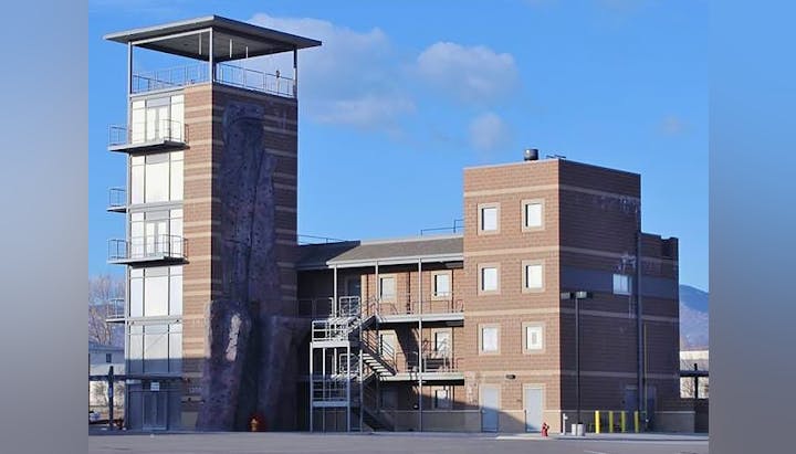 A fire training facility with a tower, simulated building, and climbing wall.