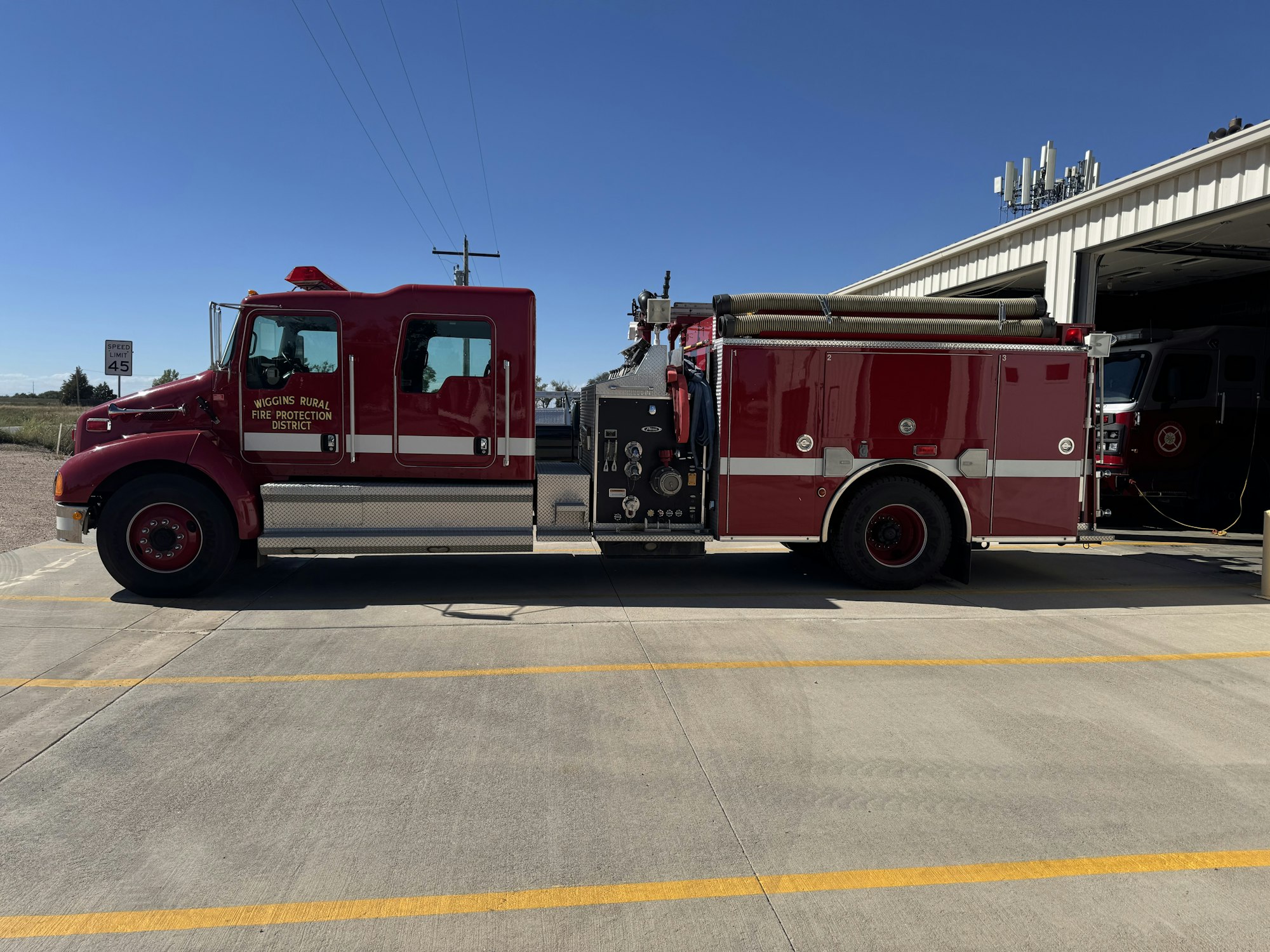 A red fire truck from Wiggins Rural Fire Protection District parked outside a fire station.
