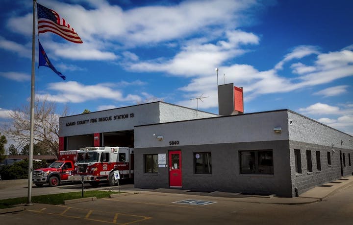 Fire station with fire truck, American flag, and handicap parking in front.