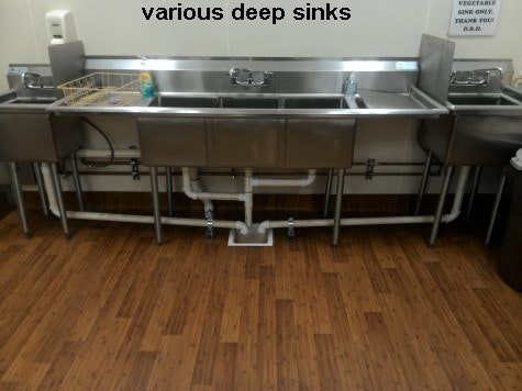 inside updated community building Several assorted deep sinks in kitchen on new floor.
