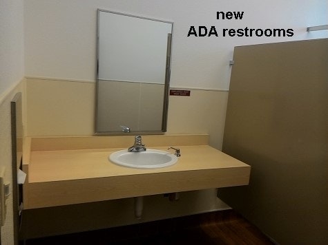 inside updated community building new ADA restroom sink, mirror, stall wall.