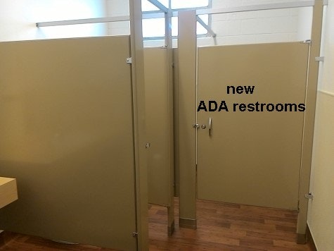 inside updated community building new ADA restroom showing stalls walls.